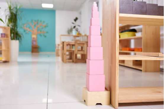 A classic pink tower displayed in a bright classroom, representing iconic Montessori toys for visual discrimination.