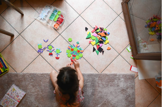 Young boy sorting colorful socks on a rug, a practical life activity with Montessori toys.