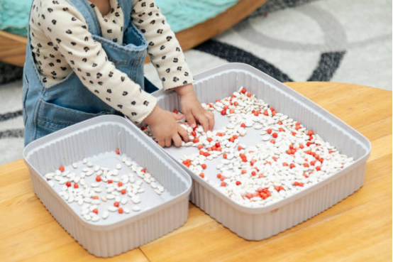 Girl sorting colorful wooden cylinders on a board, focusing on developmental Montessori toys.