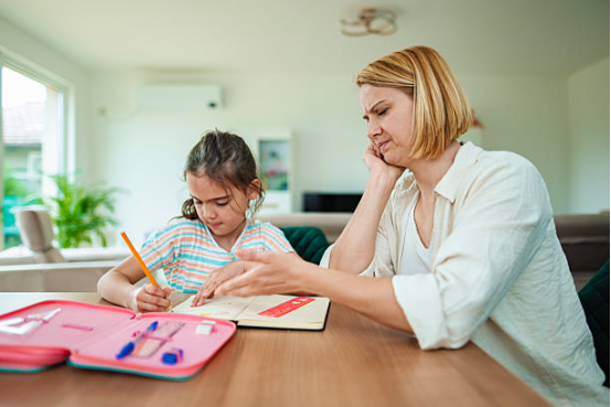 Mother and daughter doing homework together, creating a home learning environment with Montessori toys.
