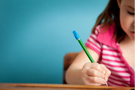 Child practicing writing skills at a desk, emphasizing the educational foundation of Montessori toys.