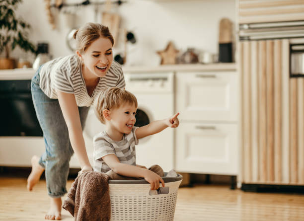Happy mother and child playing in laundry basket, like fun Montessori toys.