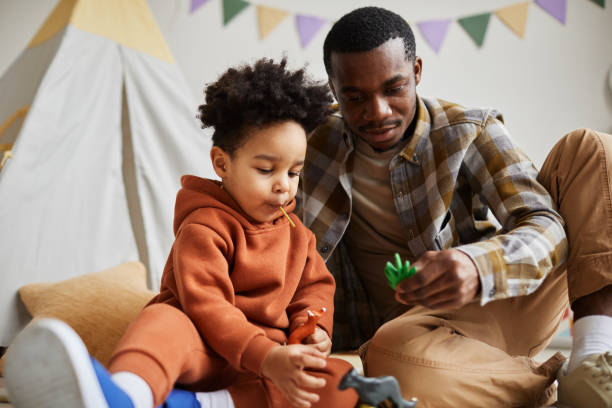 Father and toddler playing with imaginative Montessori toys on the floor.