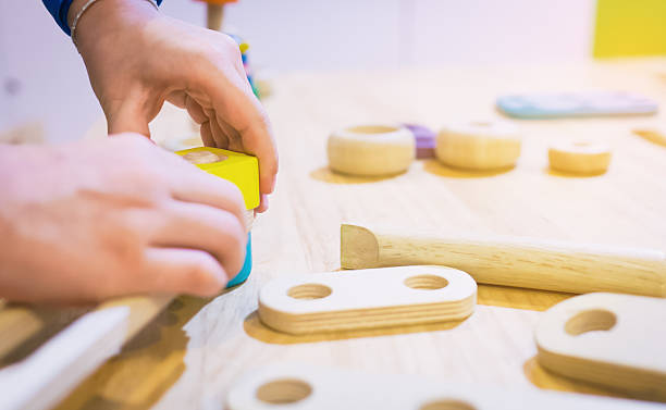 Child's hands playing with wooden blocks and shapes, demonstrating Montessori toys.