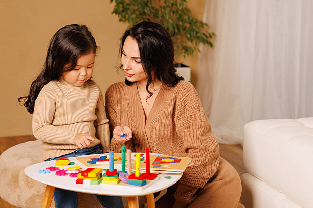 Mother and child playing with colorful geometric Montessori toys for learning.